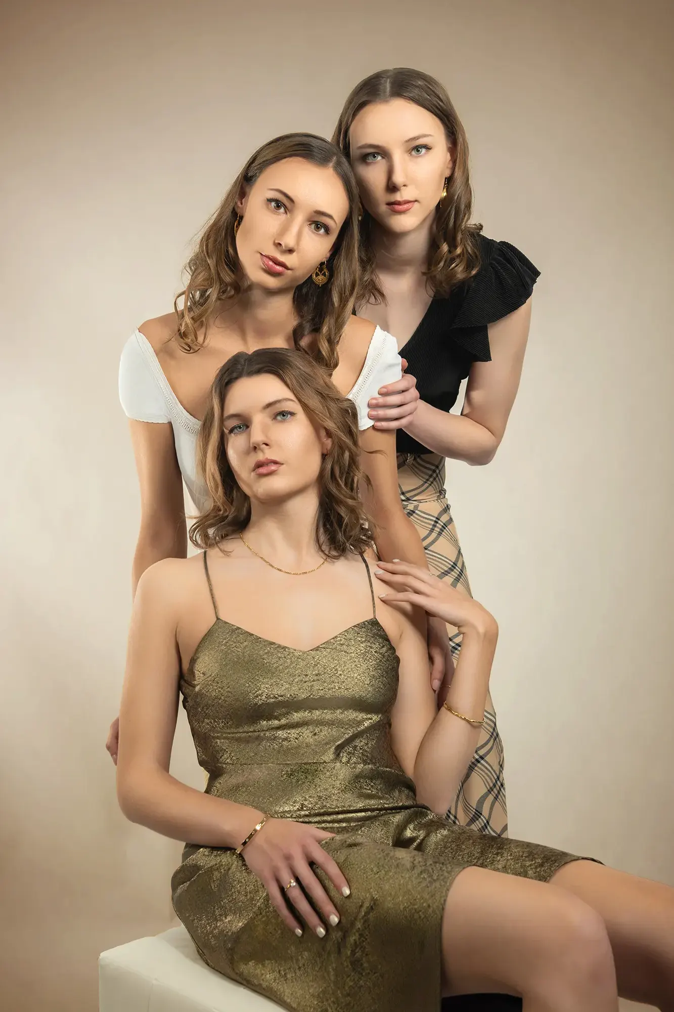 Three beautiful women in elegant poses showing variety in fashion photography